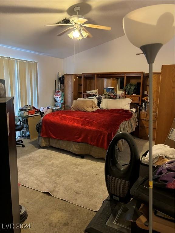 carpeted bedroom with ceiling fan and vaulted ceiling