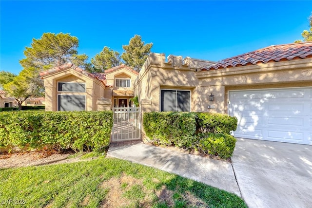 5035 Shoal Creek Cir, Las Vegas, NV 89113 - view of front of house with a tile roof, stucco siding, a garage, and a gate