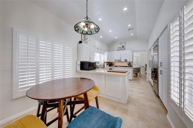 5035 Shoal Creek Cir, Las Vegas, NV 89113 - kitchen with black microwave, a peninsula, vaulted ceiling, recessed lighting, and baseboards