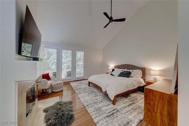 bedroom featuring ceiling fan, access to exterior, light wood-type flooring, and high vaulted ceiling