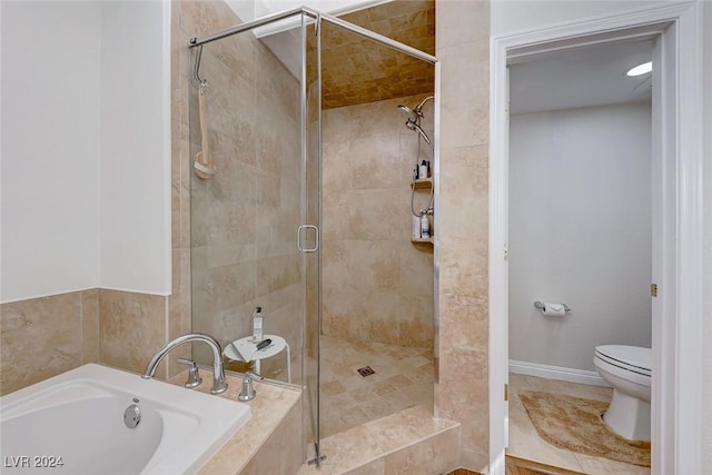 bathroom featuring tile patterned floors, toilet, and shower with separate bathtub