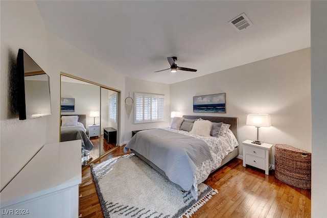 bedroom with ceiling fan, wood-type flooring, and a closet