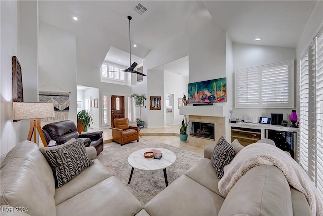 living room with ceiling fan, high vaulted ceiling, and a premium fireplace