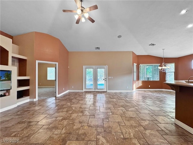 unfurnished living room with french doors, ceiling fan with notable chandelier, and vaulted ceiling