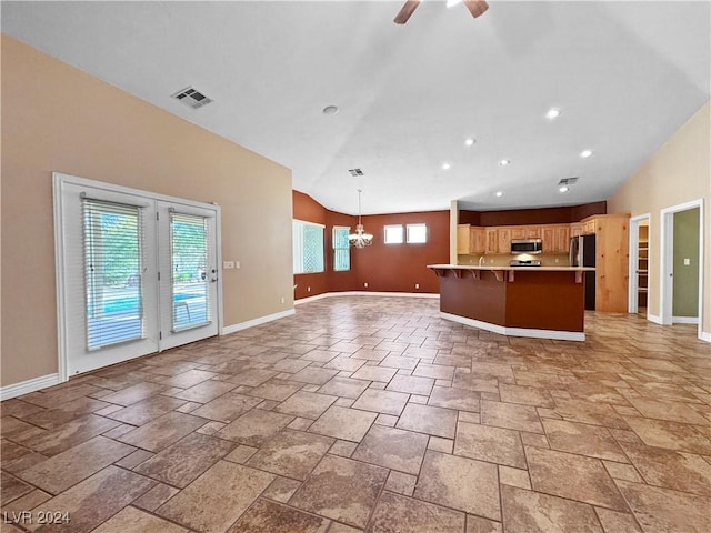 kitchen featuring ceiling fan with notable chandelier, stainless steel appliances, vaulted ceiling, and hanging light fixtures