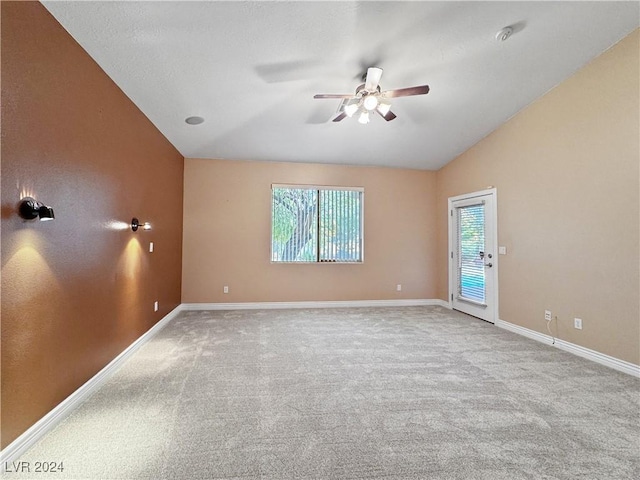 carpeted empty room with ceiling fan and lofted ceiling