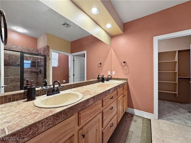 bathroom featuring tile patterned floors, vanity, and walk in shower