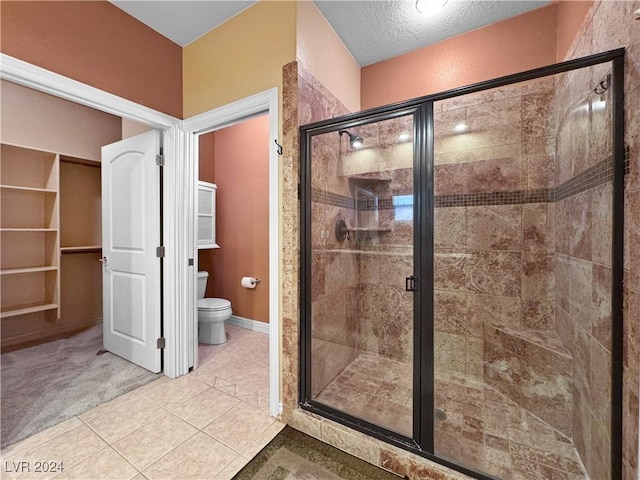 bathroom featuring toilet, a textured ceiling, tile patterned floors, and an enclosed shower