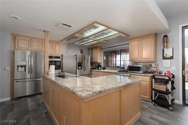 kitchen featuring light brown cabinets, a center island, stainless steel appliances, sink, and light stone counters