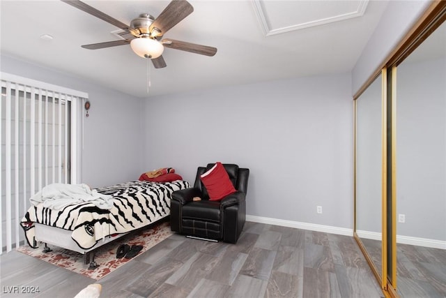 bedroom with hardwood / wood-style floors, ceiling fan, and a closet