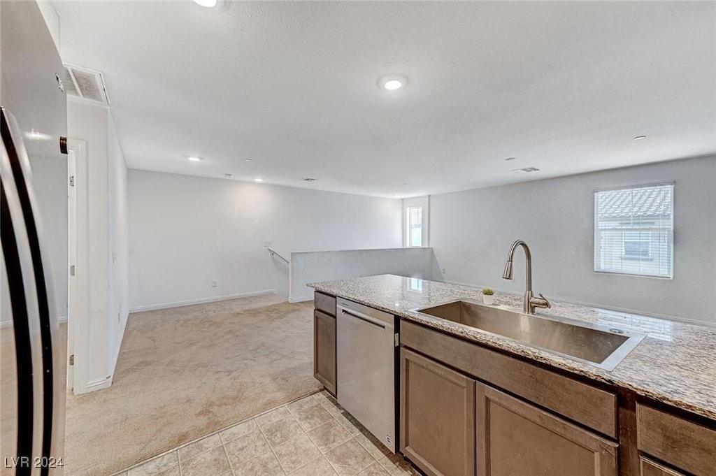 kitchen with light carpet, sink, and stainless steel dishwasher