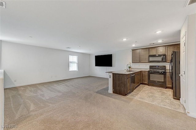 kitchen with black appliances, sink, light stone countertops, light colored carpet, and kitchen peninsula