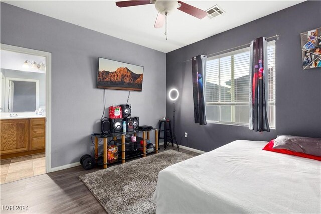 bedroom featuring sink, hardwood / wood-style flooring, ceiling fan, and ensuite bathroom