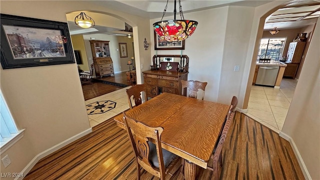 dining space featuring light tile patterned floors and ceiling fan with notable chandelier