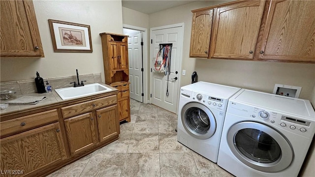 laundry room with cabinets, washing machine and dryer, and sink