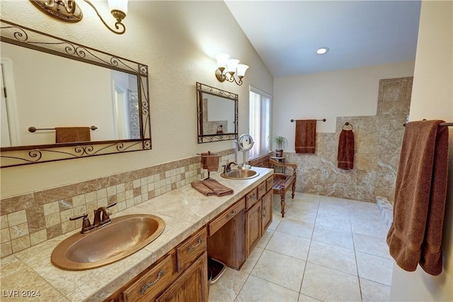 bathroom with tile patterned flooring, decorative backsplash, vanity, and vaulted ceiling