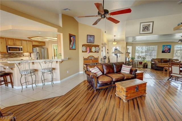 tiled living room featuring ceiling fan and lofted ceiling