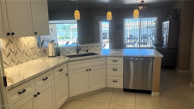 kitchen with dishwasher, white cabinets, hanging light fixtures, and sink