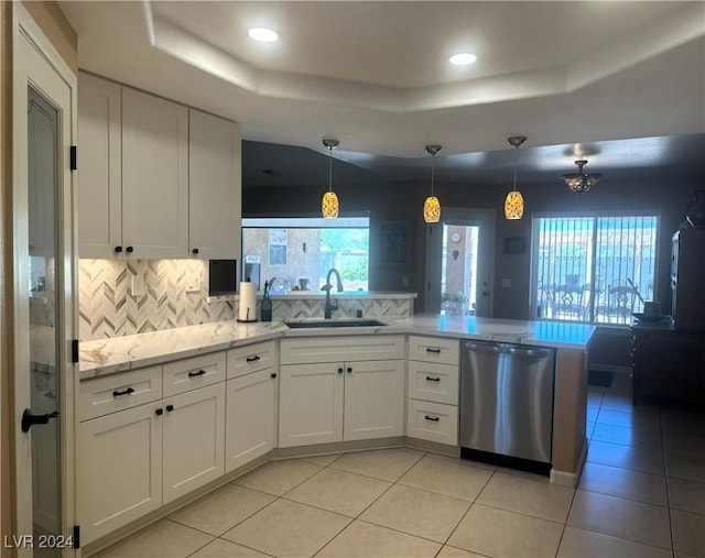 kitchen with white cabinetry, sink, kitchen peninsula, decorative light fixtures, and decorative backsplash