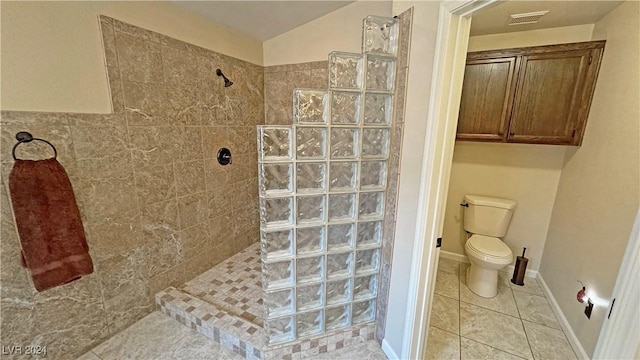 bathroom featuring tiled shower, tile patterned flooring, toilet, and vaulted ceiling