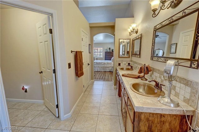 bathroom with tile patterned flooring, decorative backsplash, ceiling fan, and vanity