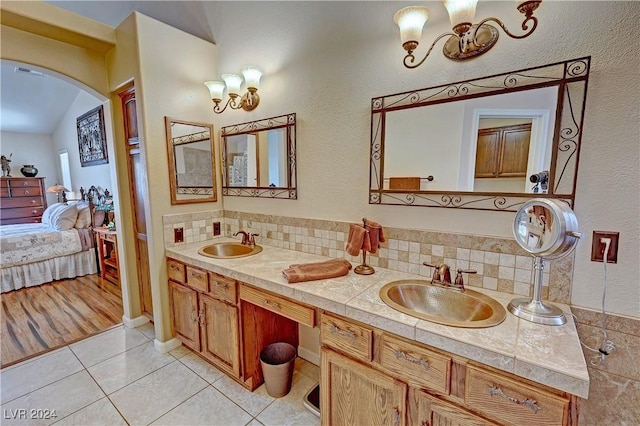 bathroom with tile patterned floors, vanity, and vaulted ceiling