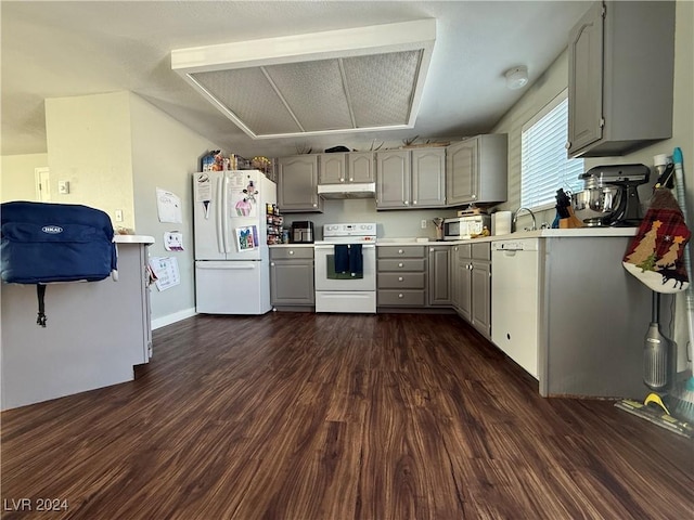 kitchen featuring white appliances, dark hardwood / wood-style floors, and gray cabinets