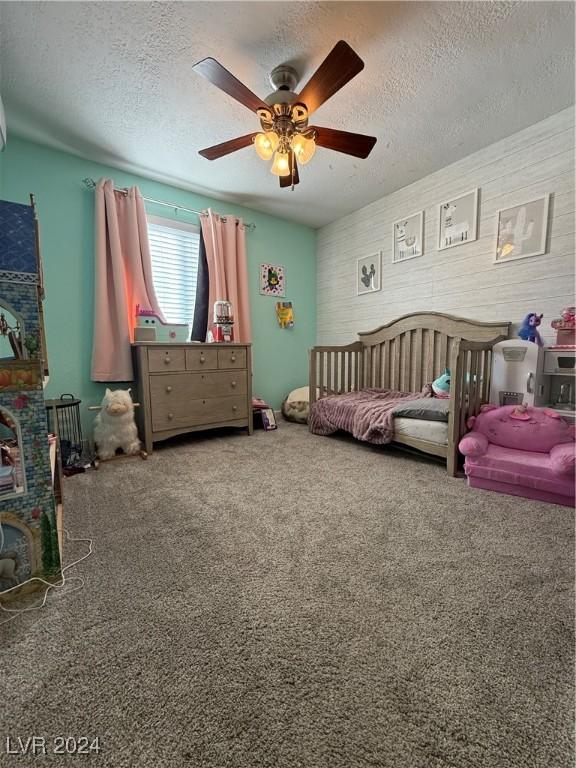 bedroom with carpet, a textured ceiling, and ceiling fan