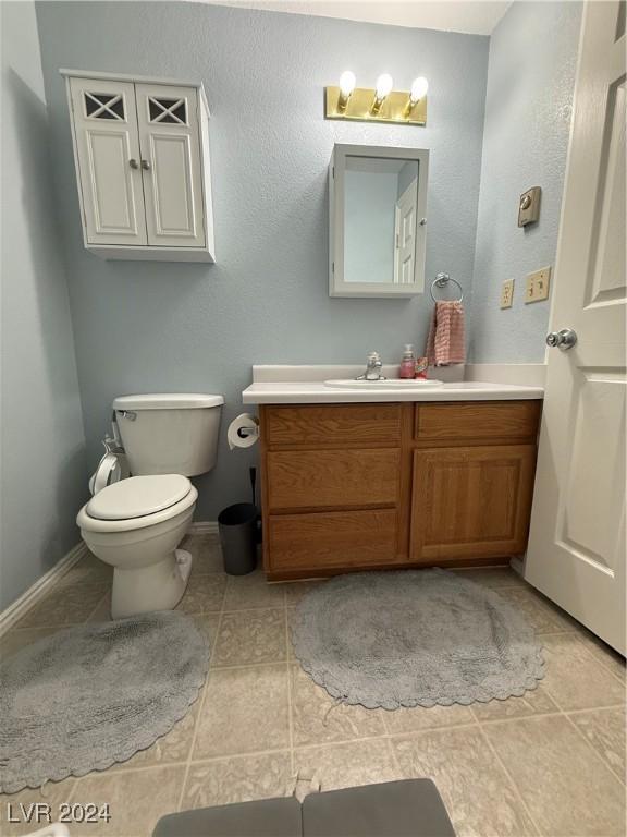 bathroom with tile patterned flooring, vanity, and toilet