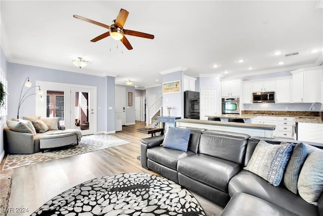 living room featuring ceiling fan, light hardwood / wood-style floors, ornamental molding, and sink