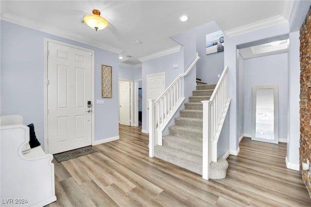 foyer entrance with light wood-type flooring and ornamental molding