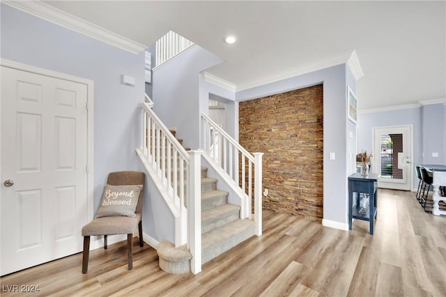 stairway with wood-type flooring and ornamental molding