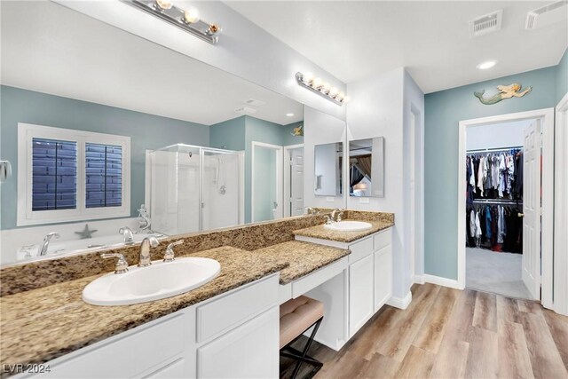 bathroom with hardwood / wood-style flooring, vanity, and a shower with door