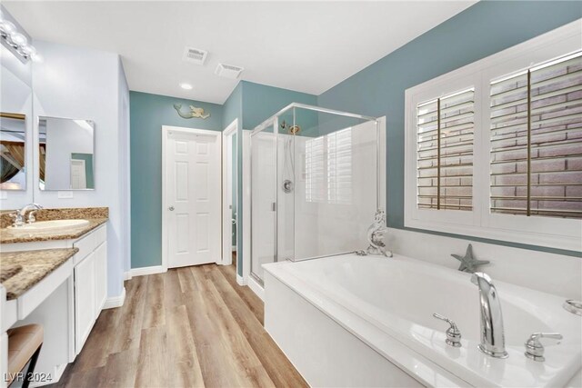 bathroom with separate shower and tub, hardwood / wood-style floors, and vanity