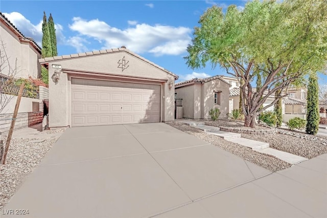 mediterranean / spanish-style home featuring driveway, fence, and stucco siding