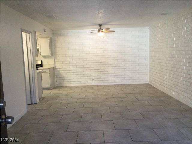 interior space with brick wall and a ceiling fan