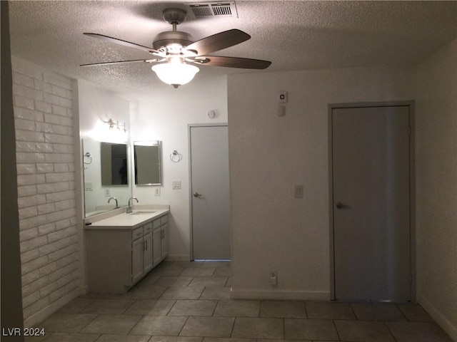 bathroom with tile patterned flooring, vanity, and a textured ceiling