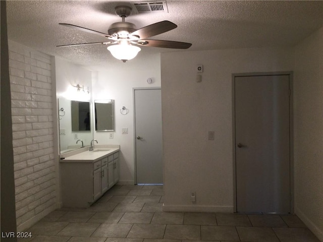 bathroom featuring a ceiling fan, a textured ceiling, vanity, baseboards, and visible vents