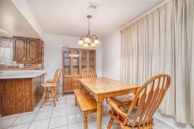 tiled dining room with a notable chandelier