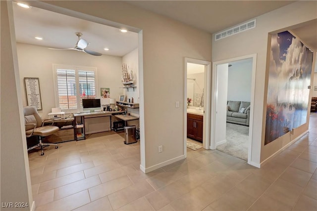 office featuring ceiling fan, light tile patterned floors, and built in desk