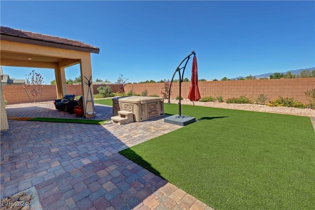 view of yard with a hot tub and a patio area