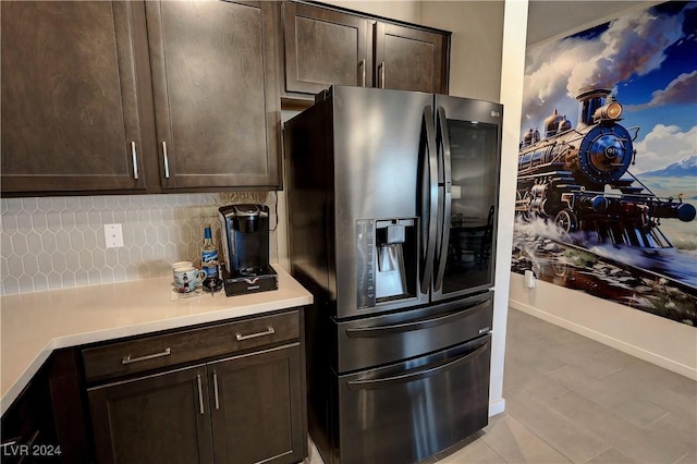 kitchen featuring backsplash, stainless steel fridge with ice dispenser, dark brown cabinets, and light tile patterned flooring