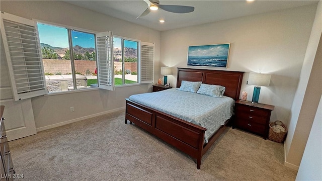 carpeted bedroom with ceiling fan and a mountain view