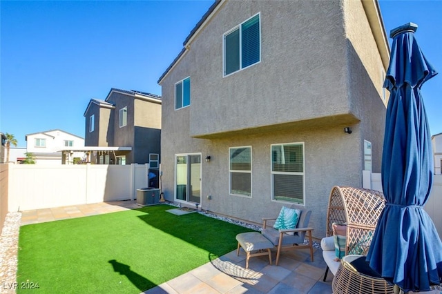 back of property with a yard, central AC unit, and a patio area