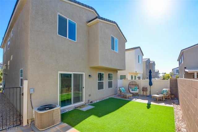 rear view of house with central AC, a patio area, and a lawn