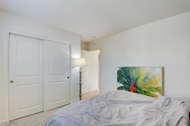 bedroom featuring light carpet and a closet