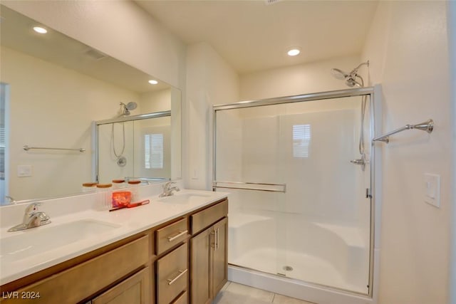 bathroom featuring tile patterned floors, a shower with door, and vanity