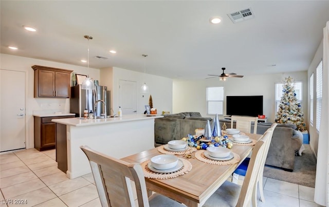 dining area featuring ceiling fan, sink, and light tile patterned floors