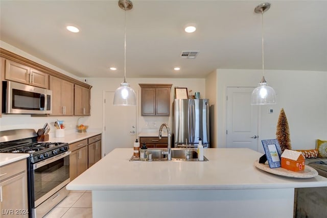 kitchen with hanging light fixtures, sink, stainless steel appliances, and a kitchen island with sink