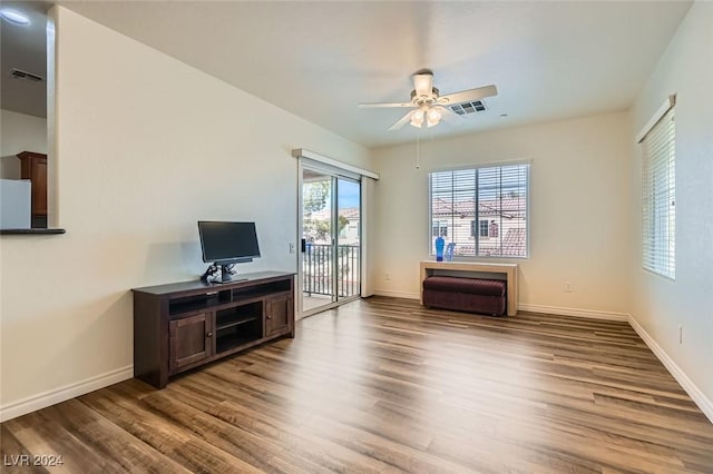 living room with dark hardwood / wood-style flooring and ceiling fan